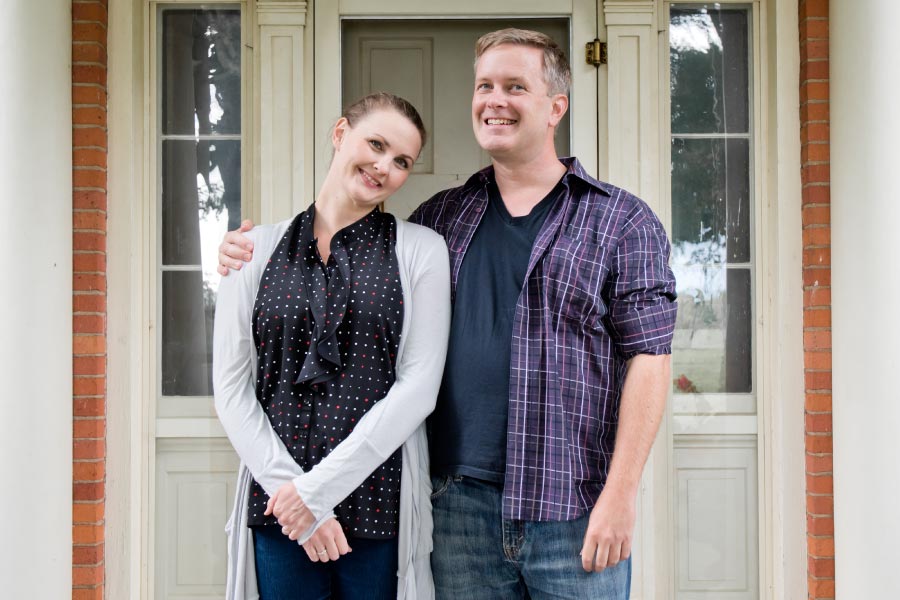 Couple standing in front of home asking what a wealth advisor is